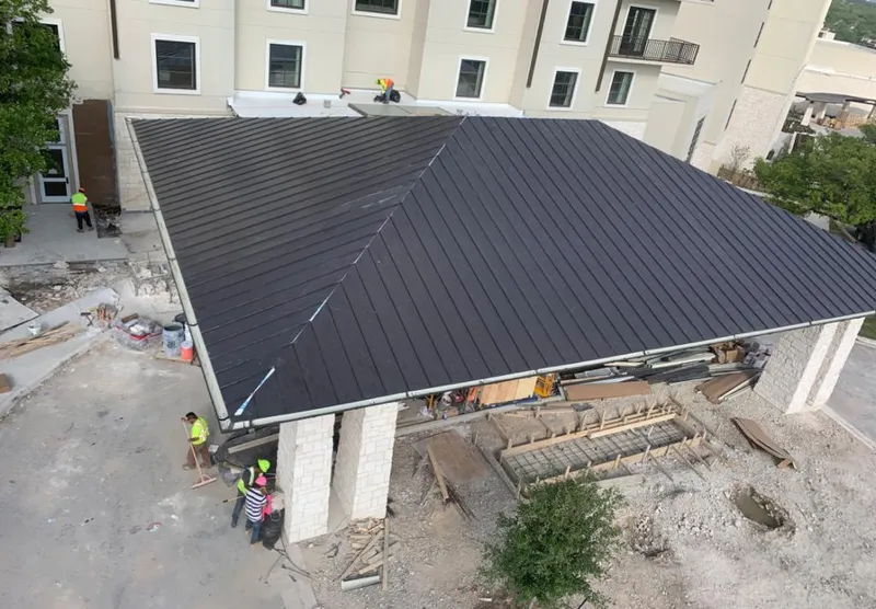 Metal roofing installation team working on a commercial building in Lafayette
